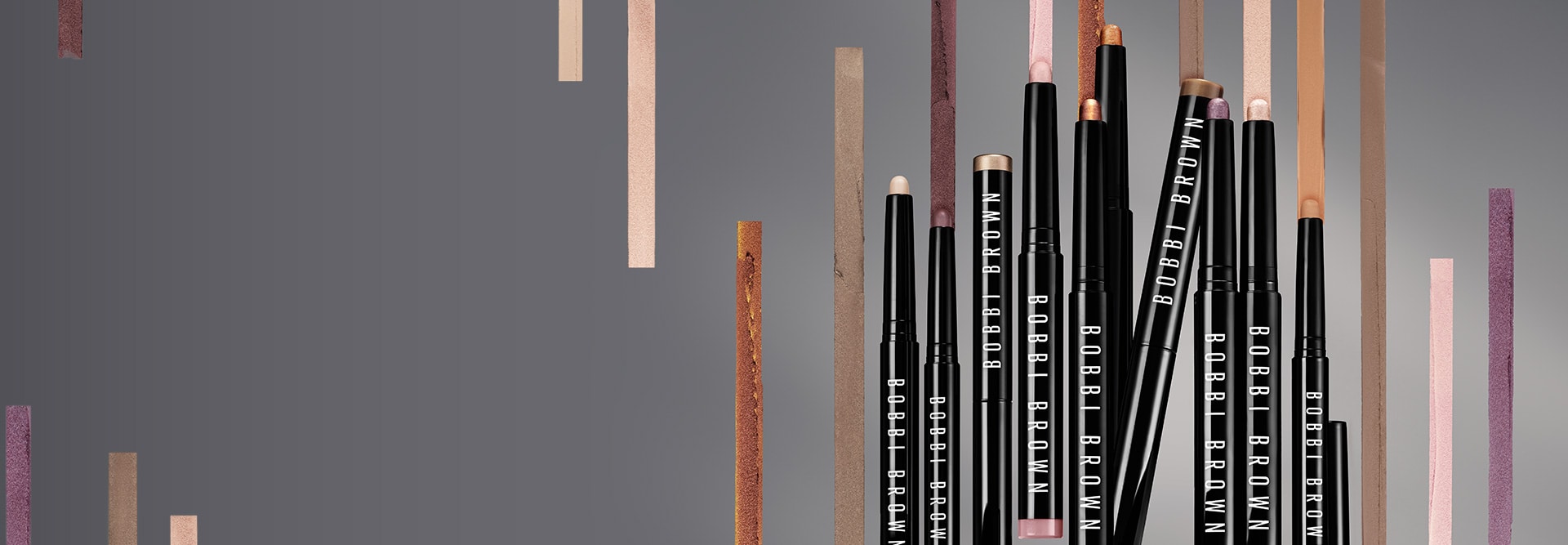 Selection of bestselling Long-Wear Cream Shadow Stick shades, stood in front of a grey background and swatches