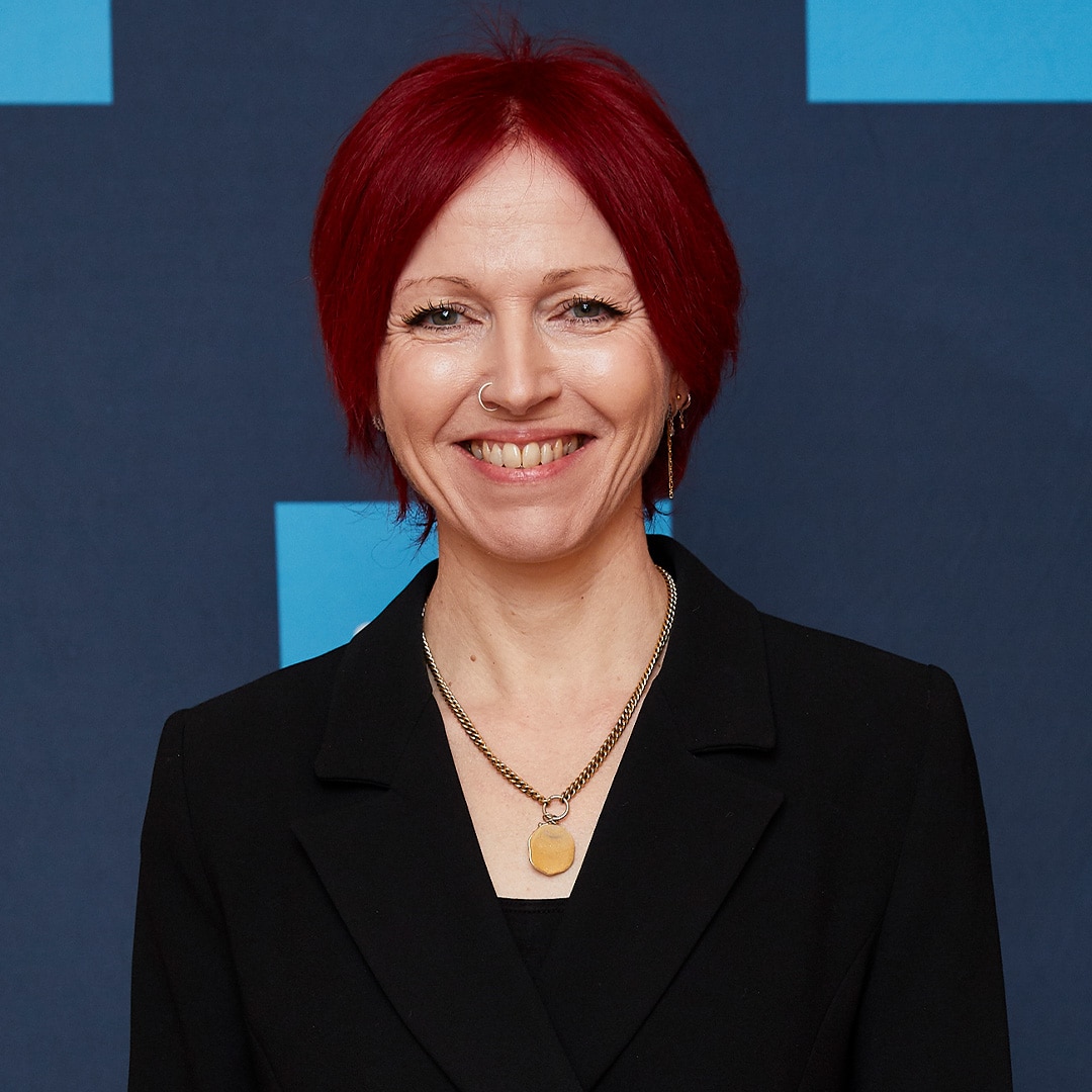 CEO smiling in front of a blue background